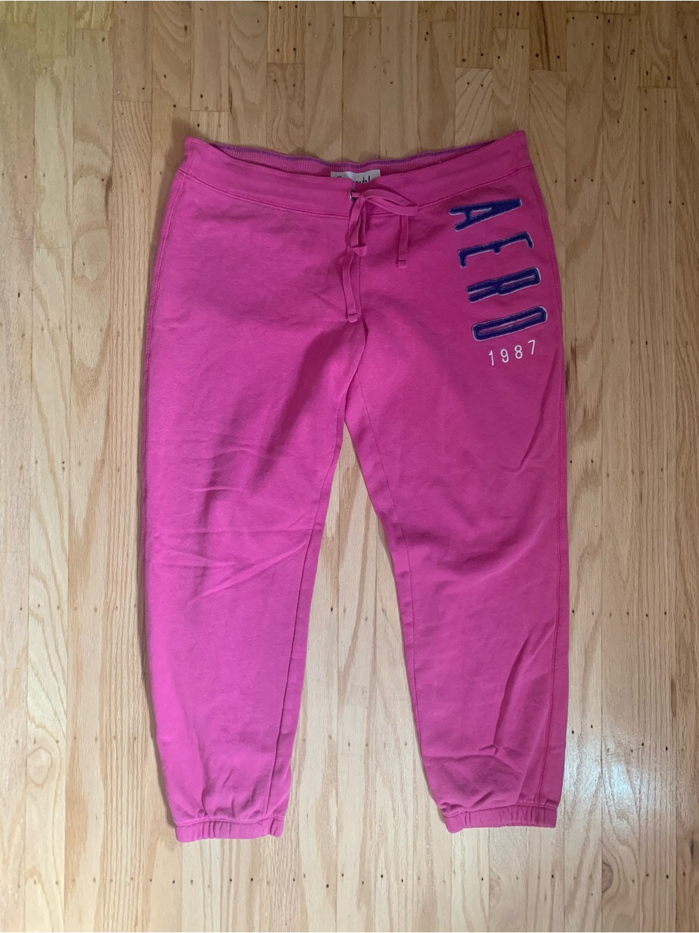 Aeropostale pink sweatpants with blue vertical text reading 'AERO 1887'